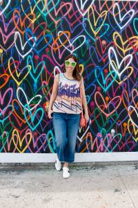 Anna Roufos Sosa in front of a heart print wall in LA wearing Mother of Pearl and Gucci.